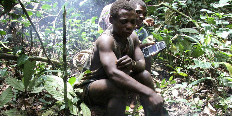 Deux Baka utilisent un GPS pour positionner sur une carte leurs zones de chasse et leurs lieux sacrés dans les forêts du nord de la République du Congo. CRÉDITS : REUTERS
