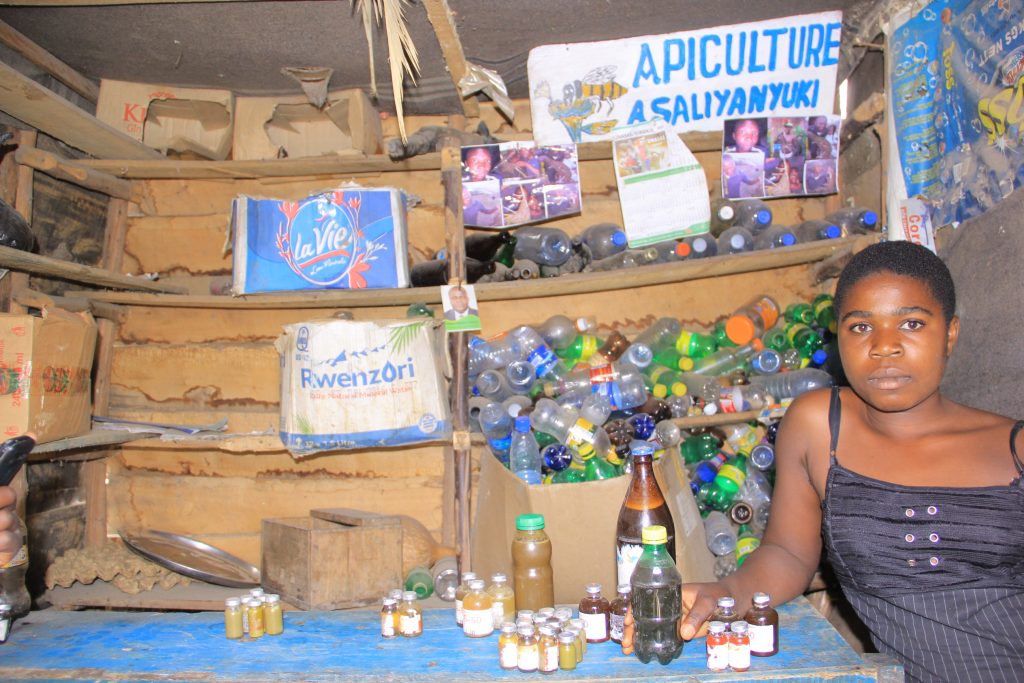 eannine, une vendeuse dans son officine de miel à Kanyabayonga